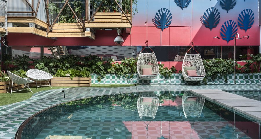 בריכה בבית האח הגדול עם כיסאות נדנדה